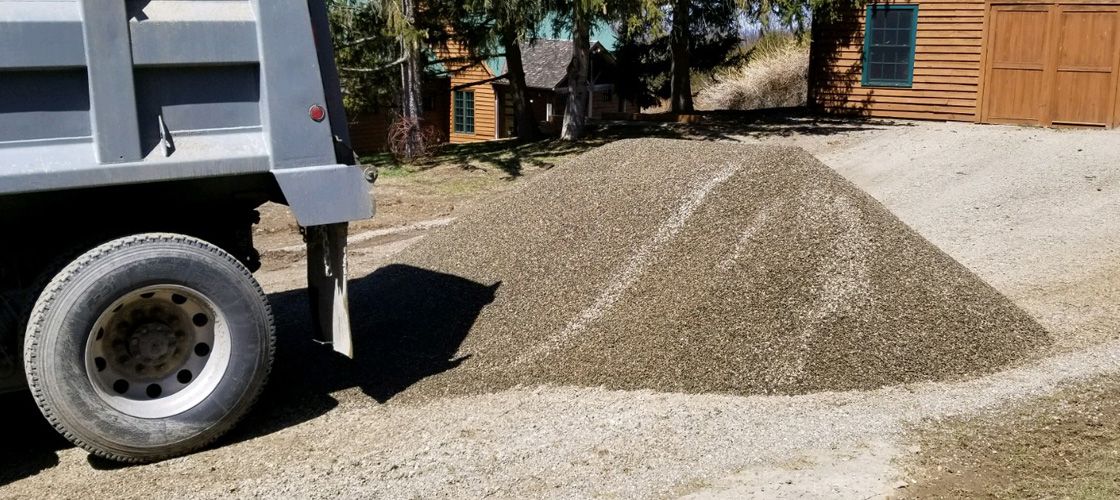 Miller Supply dump truck delivering a load of bulk gravel